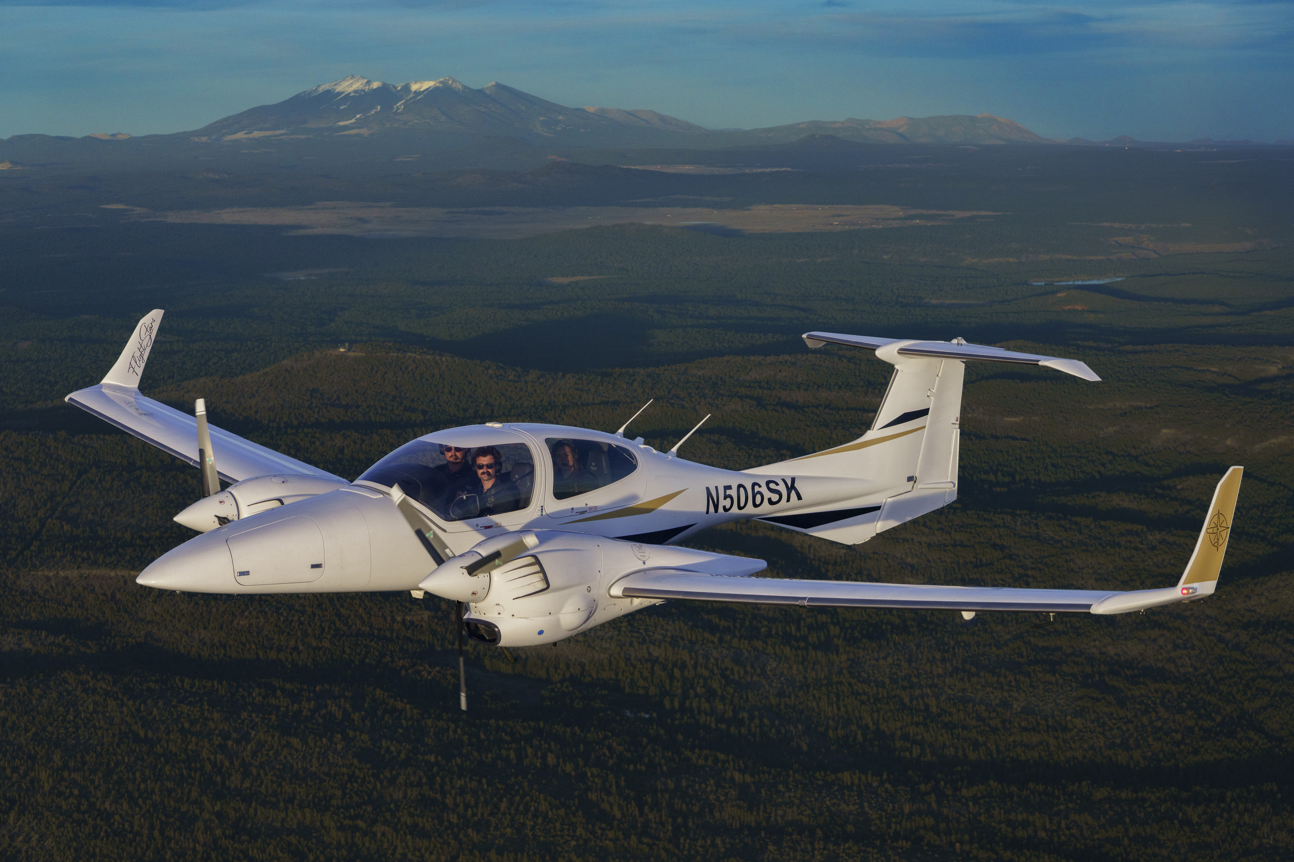 Diamond DA42 in flight with snow-capped mountain in the background